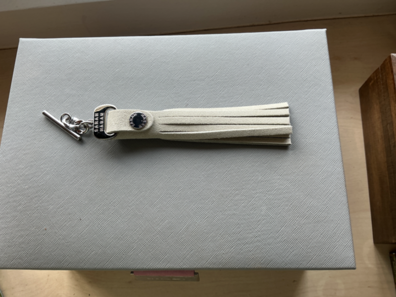 Interchangeable suede tassel with silver hardware.